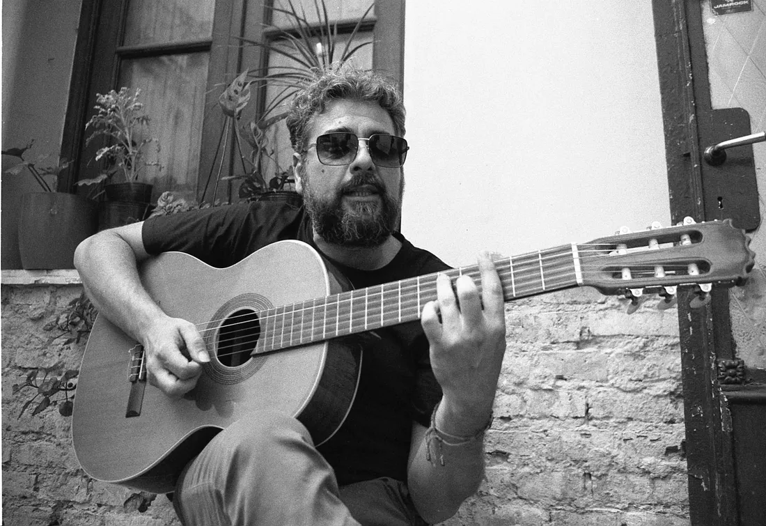Faba tocando la guitarra criolla junto a la ventana